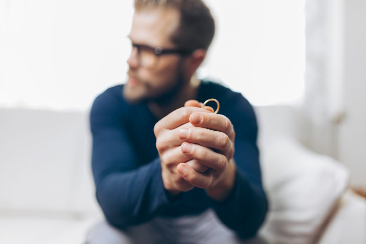 heartbroken man holding a wedding ring Как оформить развод через МФЦ по обоюдному согласию и без мужа