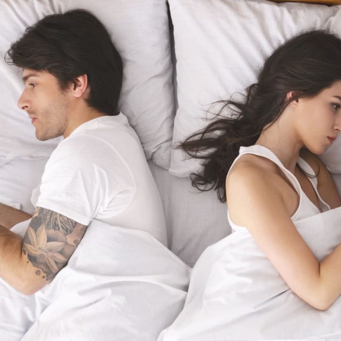 пара в ссоре лежат в кровати смотрят в телефоны