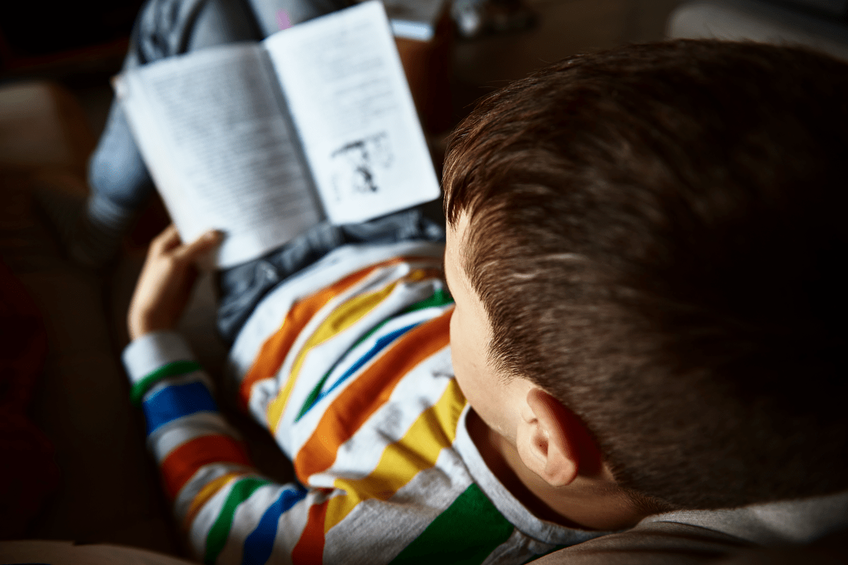 Ребенок читает книгу дома