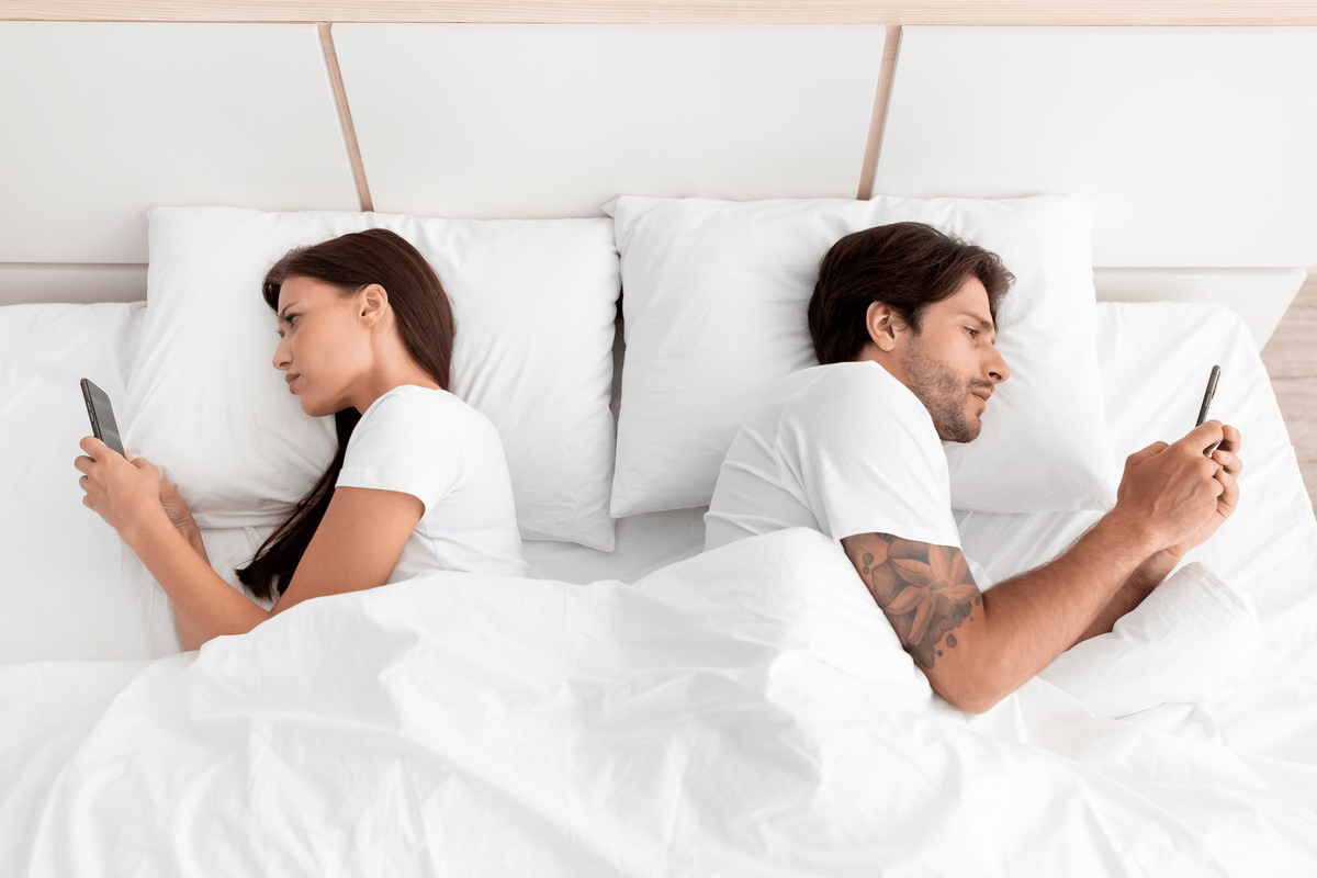 Мужчина и женщина в постели не обращают друг на друга внимания
